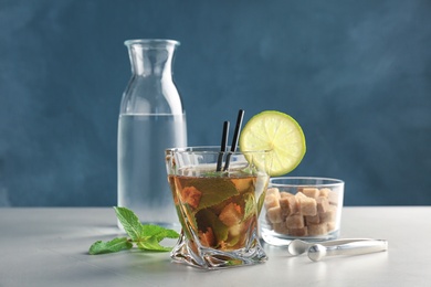 Glass of delicious mint julep cocktail on table