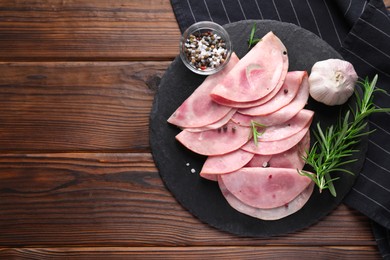 Photo of Tasty ham with rosemary, garlic, sea salt and peppercorns on wooden table, top view. Space for text