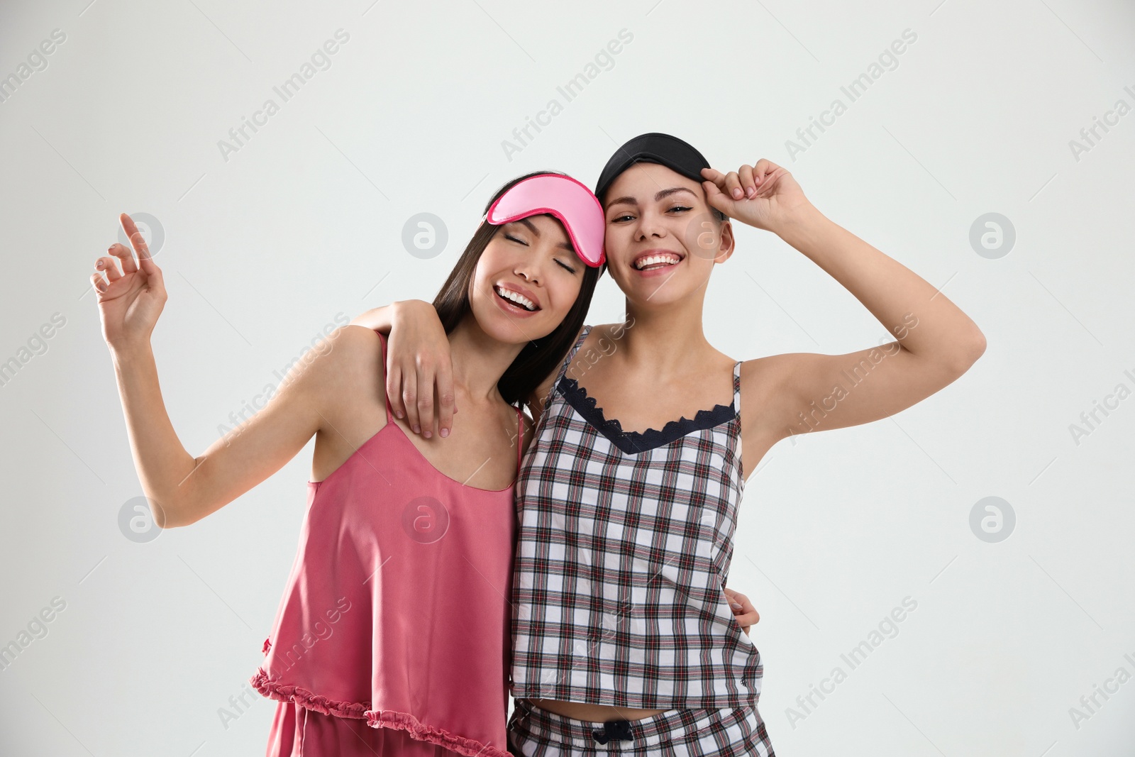 Photo of Beautiful women in pajamas on light grey background. Bedtime