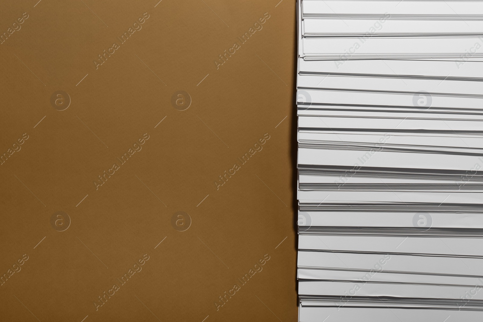 Photo of White paper sheets on brown background, flat lay. Space for text