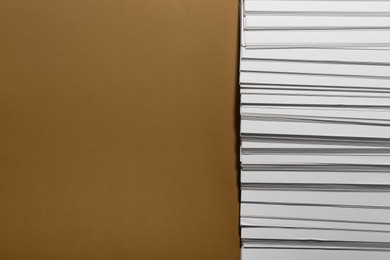 Photo of White paper sheets on brown background, flat lay. Space for text