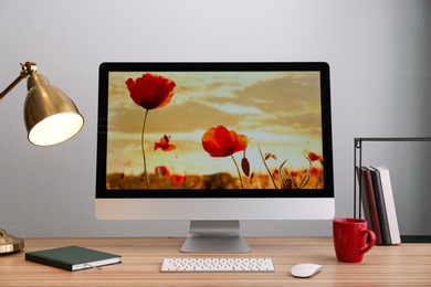 Comfortable workplace with computer on desk against white wall