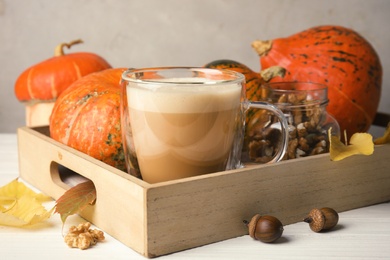 Composition with cup of tasty pumpkin spice latte on table