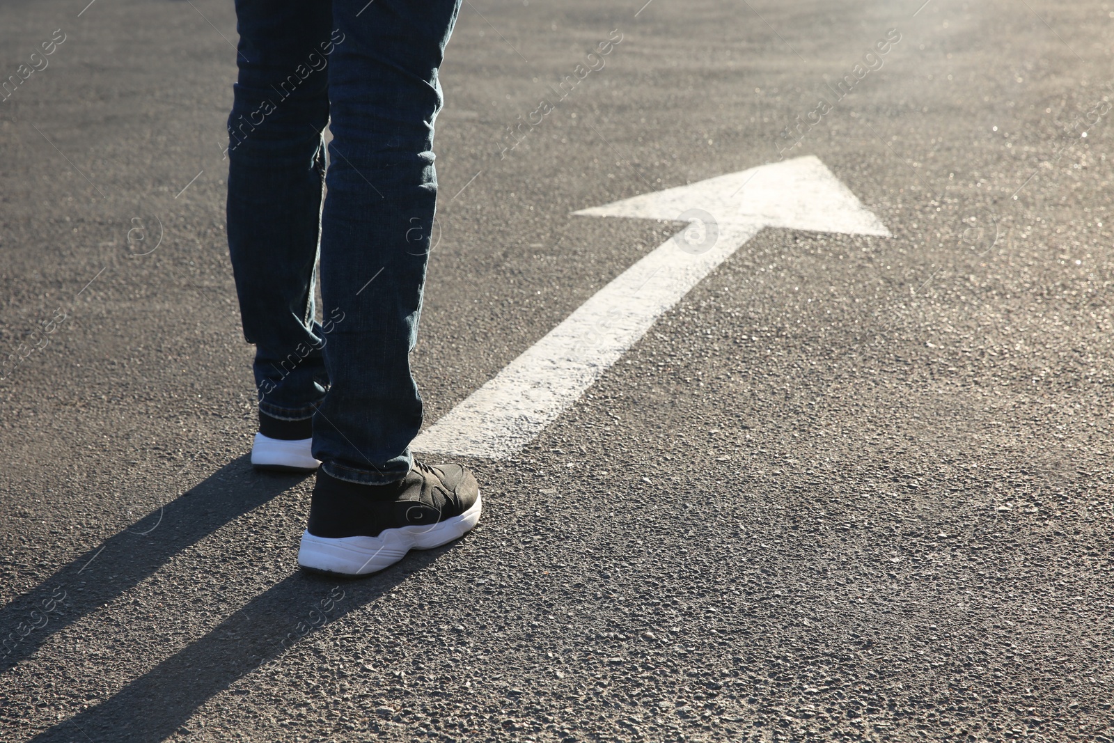 Photo of Man going along road with arrow marking, closeup