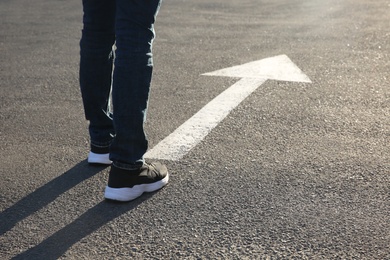 Photo of Man going along road with arrow marking, closeup