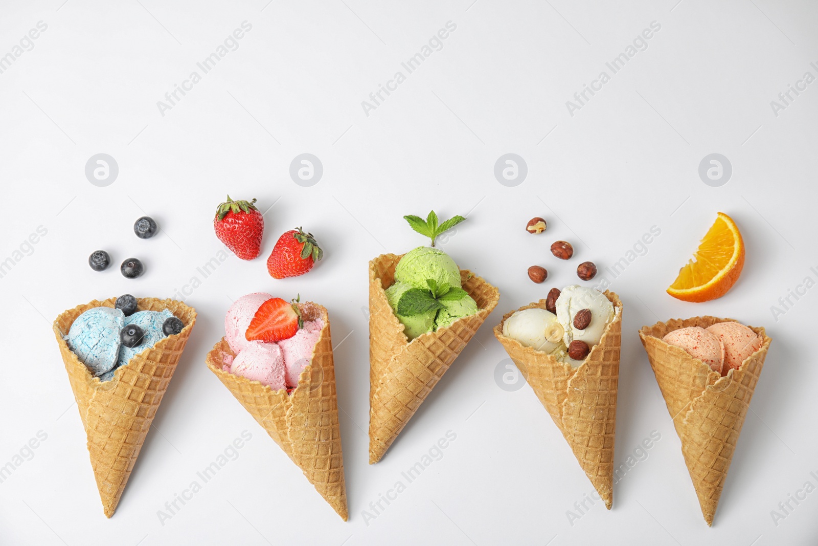 Photo of Composition with delicious ice creams in waffle cones on white background, top view