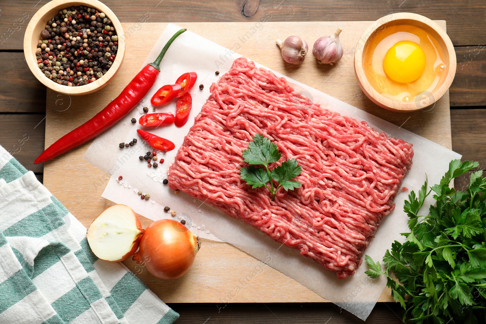 Photo of Raw ground meat and different products on wooden table, flat lay