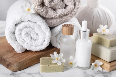 Composition with spa supplies and flowers on white marble table