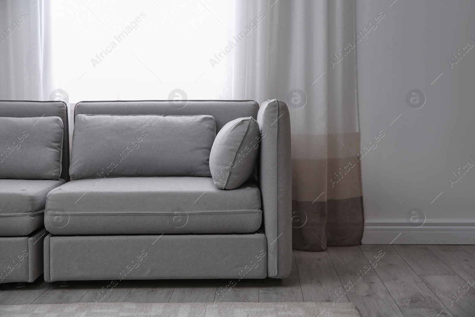 Photo of Simple living room interior with comfortable sofa near window. Space for text