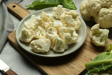 Photo of Cut fresh raw cauliflowers on grey table