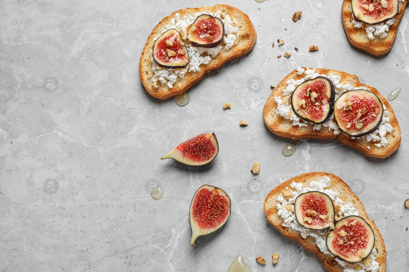 Photo of Bruschettas with cheese and figs on marble table, flat lay. Space for text