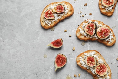 Photo of Bruschettas with cheese and figs on marble table, flat lay. Space for text