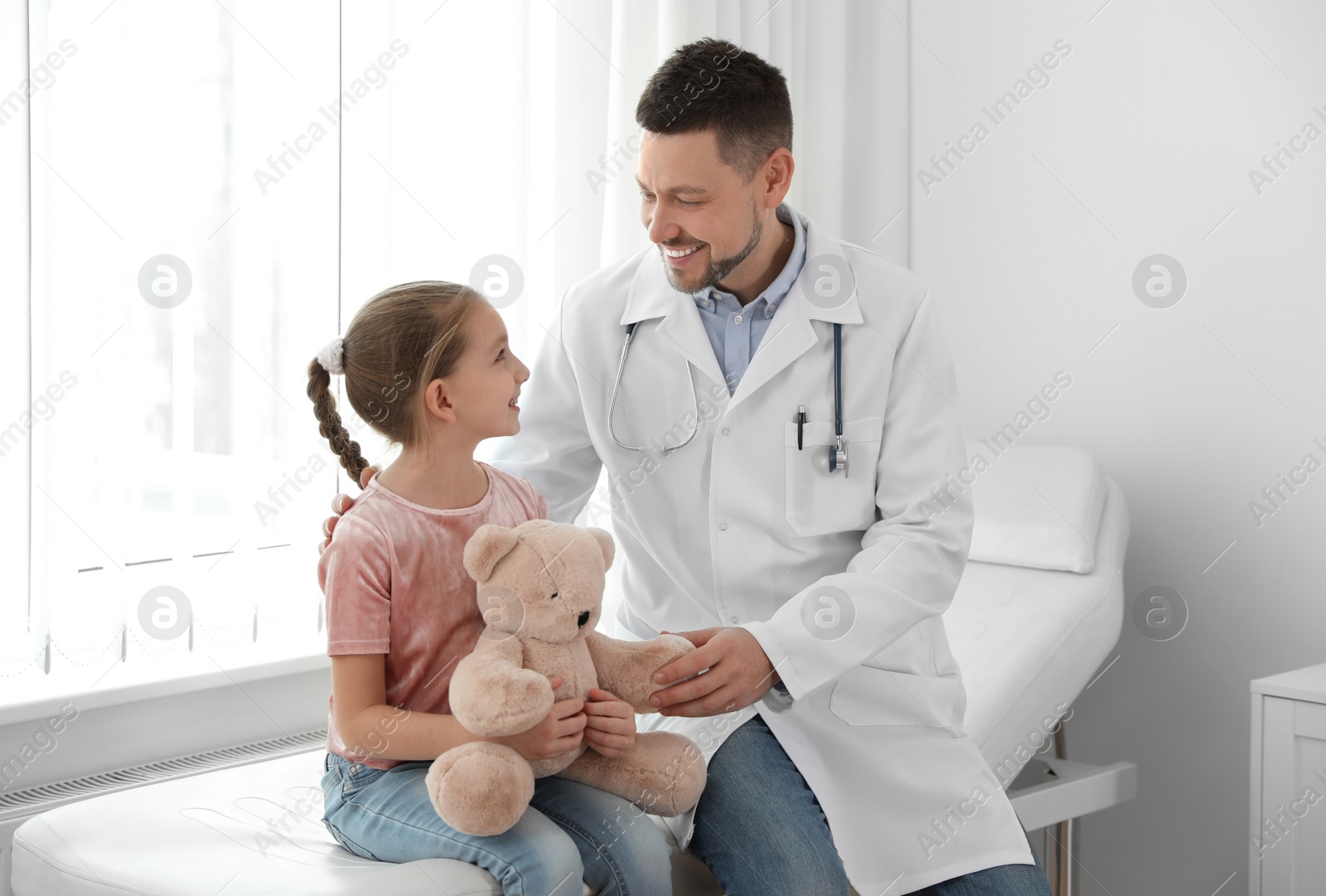 Photo of Children's doctor working with little patient in clinic