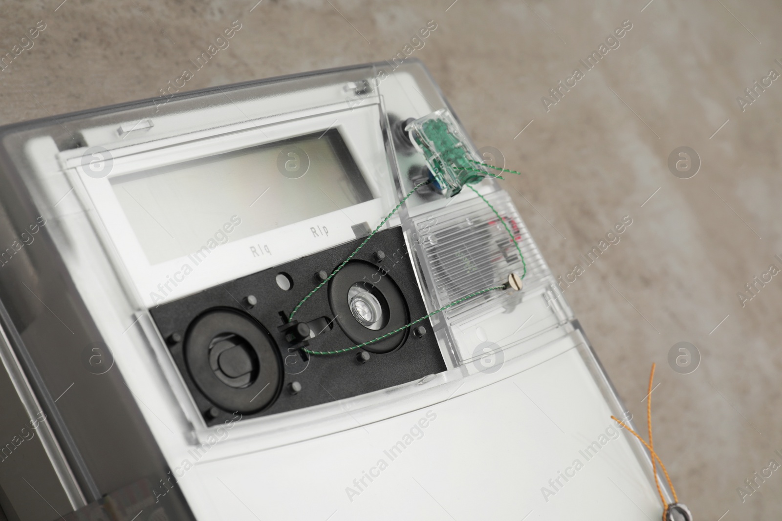 Photo of Electric meter on grey background, closeup. Measuring device
