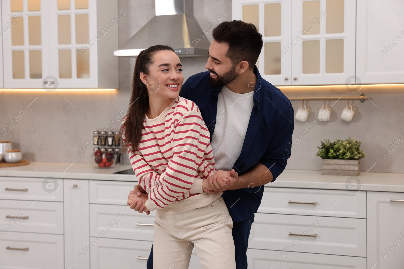 Photo of Happy lovely couple dancing together in kitchen