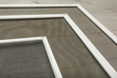 Photo of Set of window screens on wooden floor, closeup