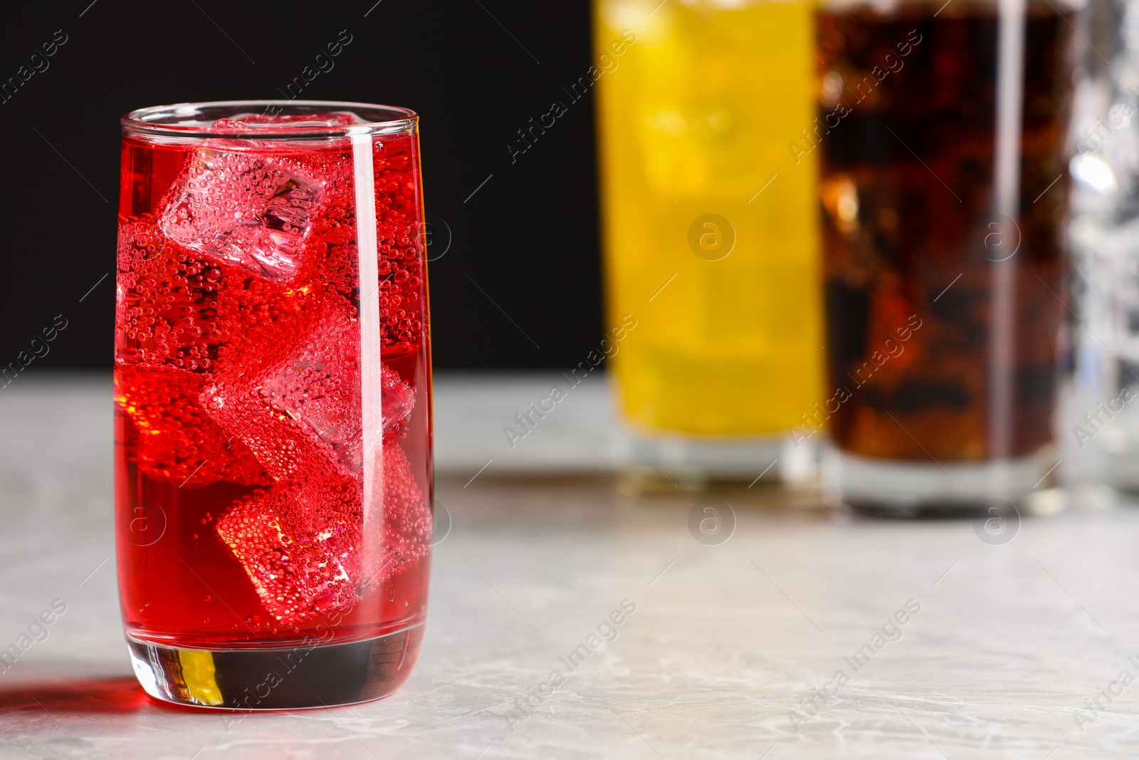 Photo of Glass of refreshing soda water with ice cubes on white table, closeup. Space for text