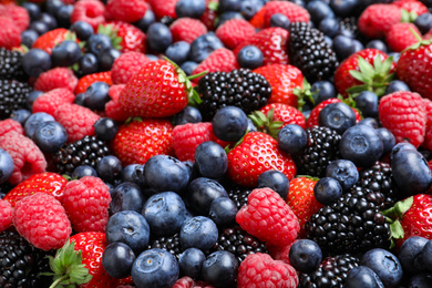 Photo of Mix of different ripe tasty berries as background, closeup view