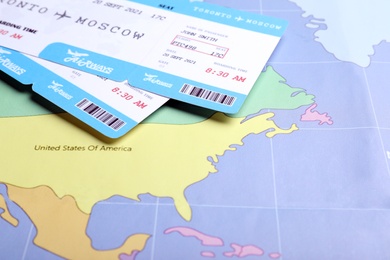 Tickets on world map, closeup. Travel agency concept