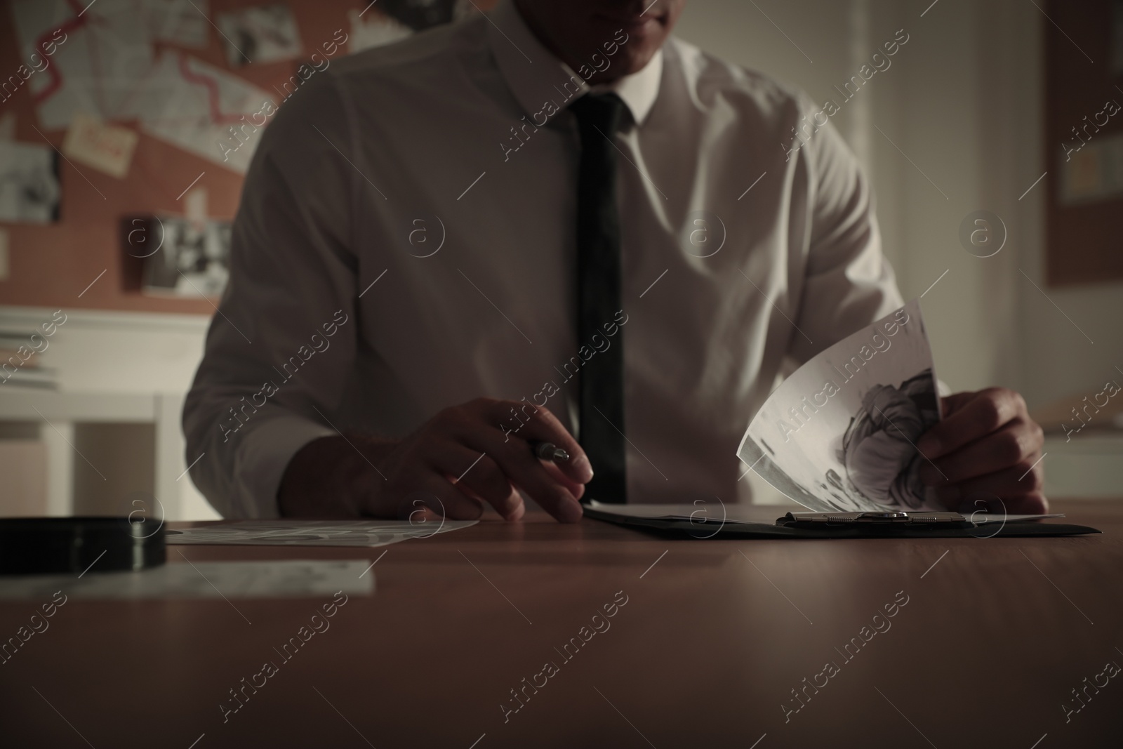 Photo of Detective working at desk in his office, closeup
