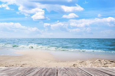 Image of Empty wooden surface near sandy beach and sea on sunny day