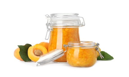 Photo of Jars of apricot jam and fresh fruits on white background