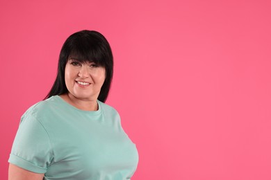 Photo of Beautiful overweight mature woman with charming smile on pink background. Space for text