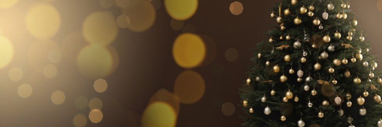 Image of Beautifully decorated Christmas tree on brown background, space for text. Banner design