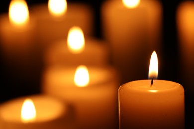 Burning candles on black background, closeup. Space for text