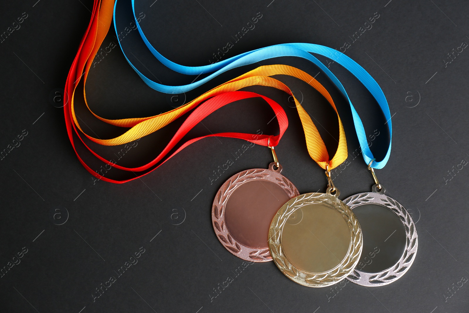 Photo of Gold, silver and bronze medals on black background, flat lay. Space for design