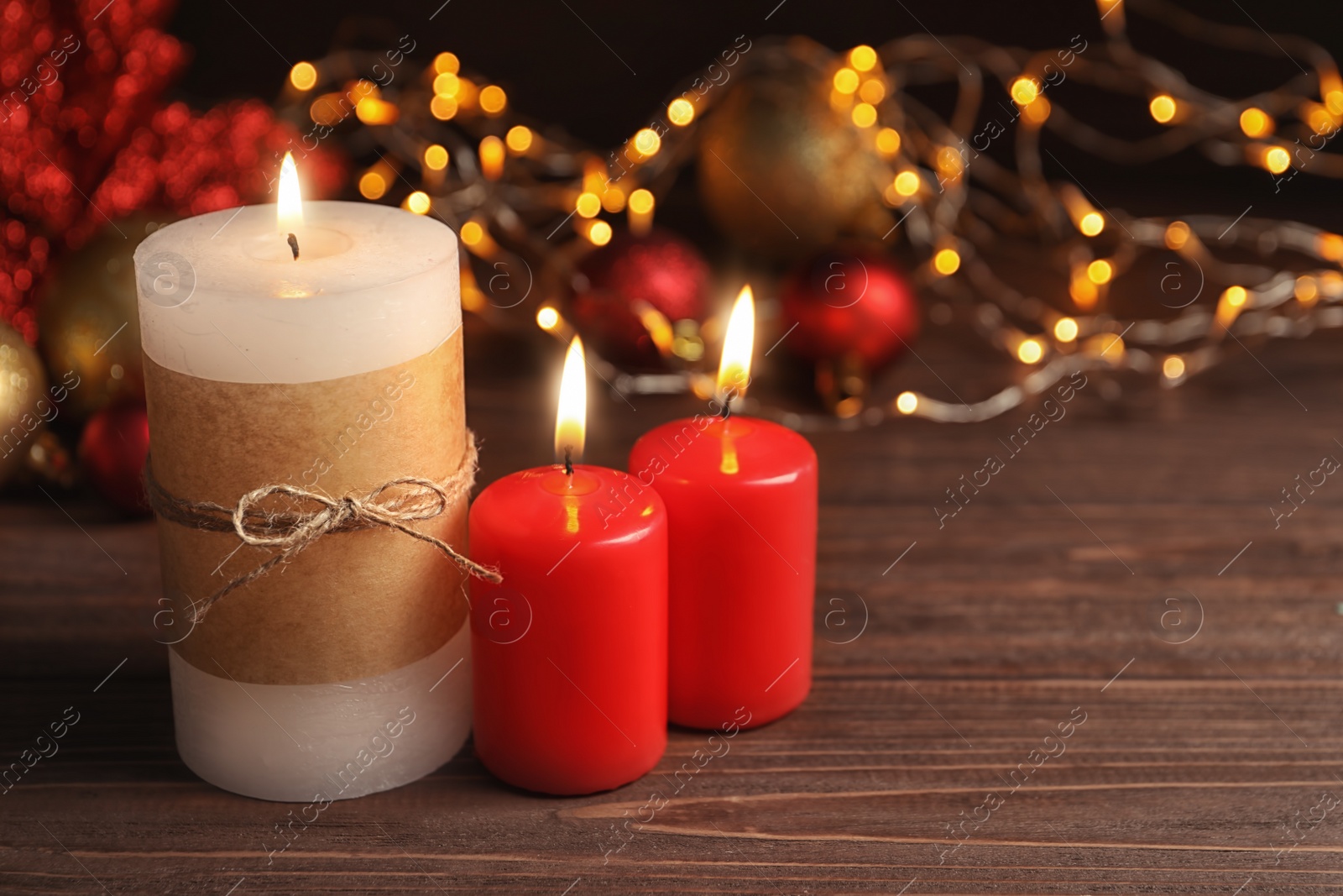 Photo of Beautiful composition with burning wax candles on table against blurred lights