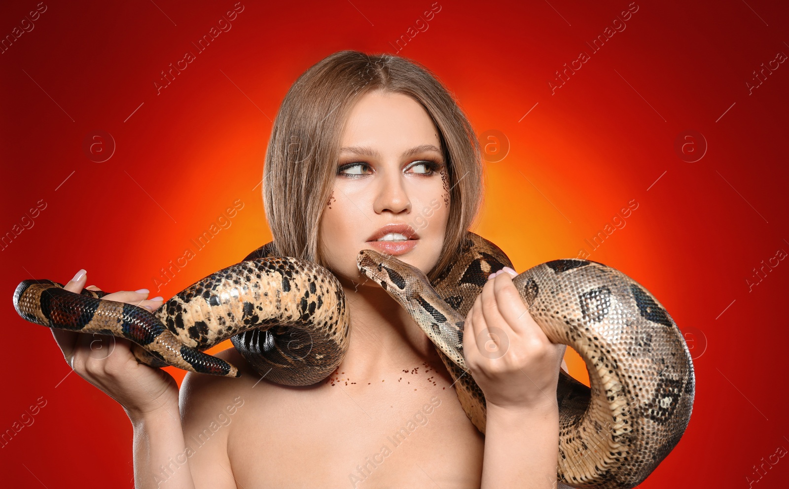 Photo of Beautiful woman with boa constrictor on bright colorful  background