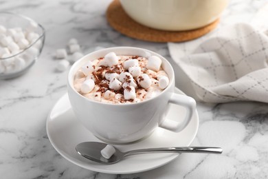 Photo of Cup of aromatic hot chocolate with marshmallows and cocoa powder served on white marble table, closeup
