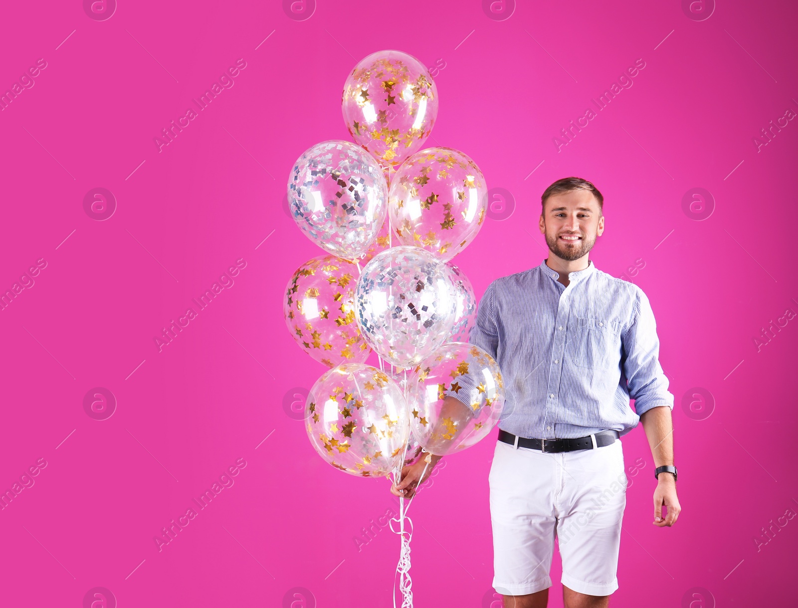 Photo of Young man with air balloons and space for text on color background