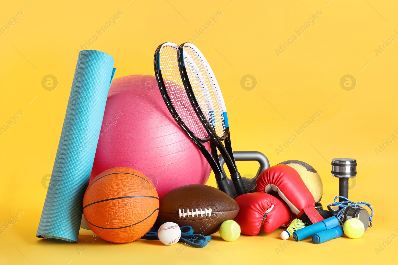 Photo of Set of different sports equipment on yellow background