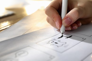 Photo of Woman drawing cartoon sketches at workplace, closeup. Pre-production process