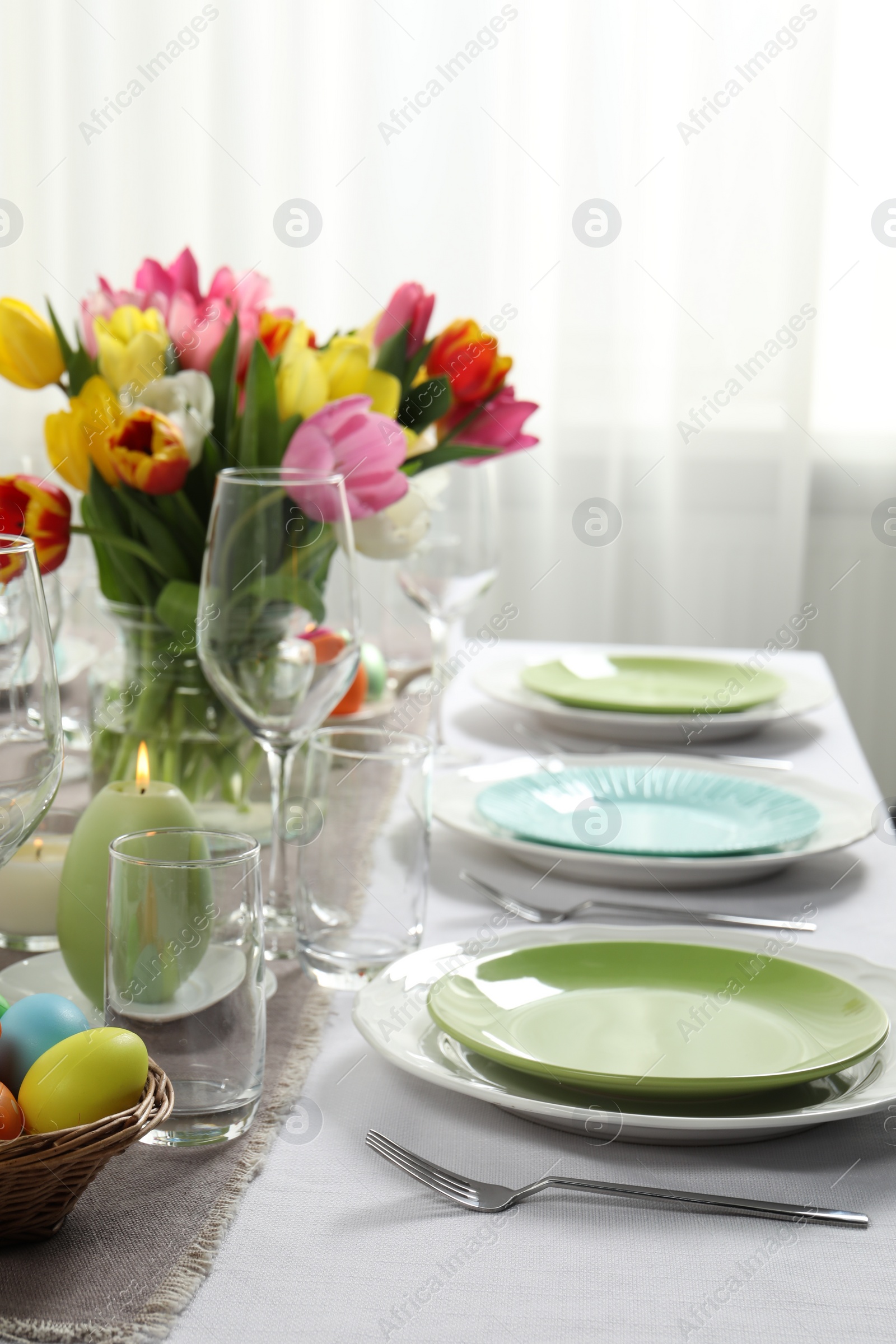 Photo of Easter celebration. Festive table setting with beautiful flowers and painted eggs