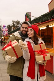 Lovely couple with Christmas presents at winter fair