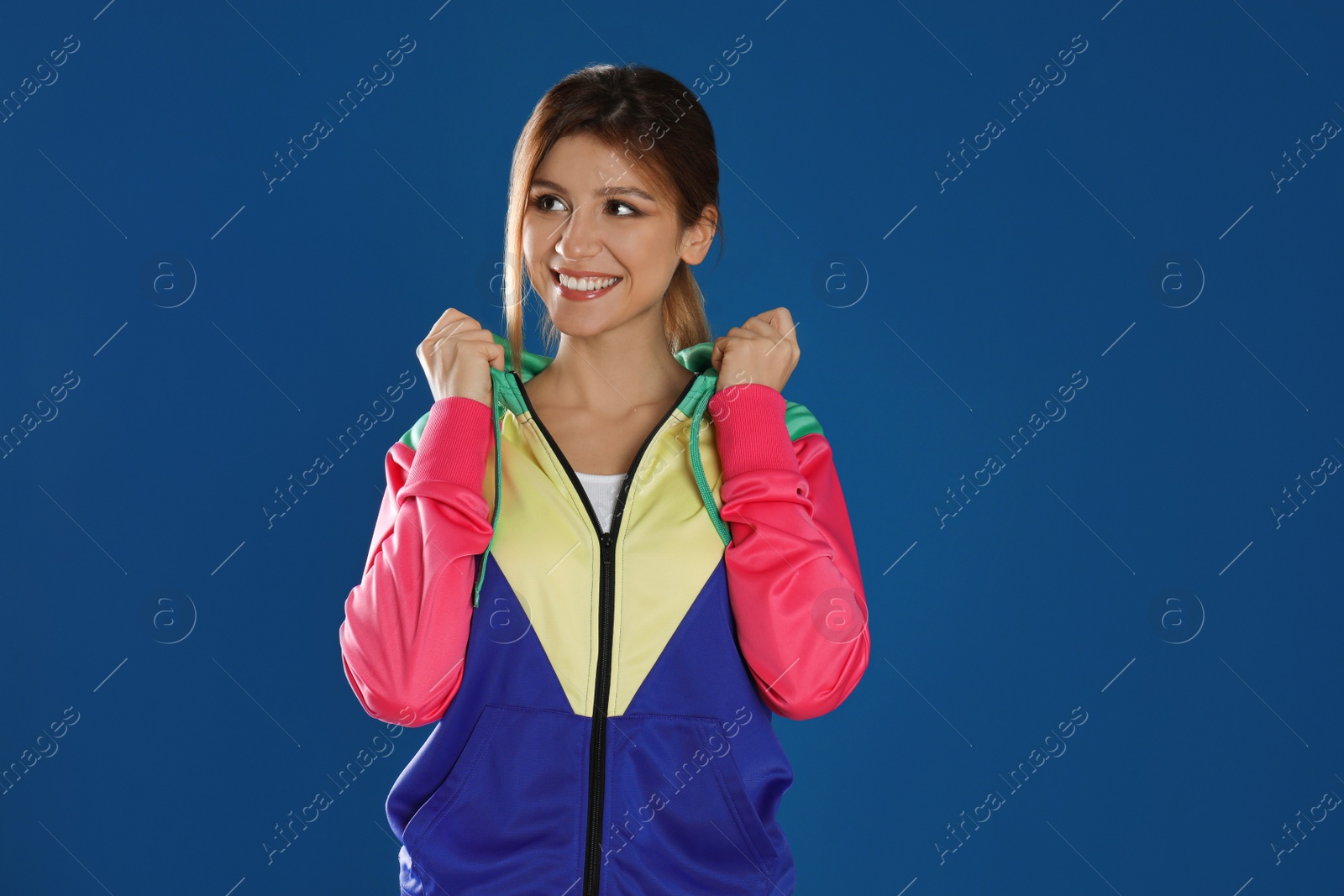 Photo of Happy woman in sportswear on blue background, space for text