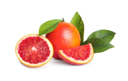 Photo of Whole and cut red oranges with green leaves on white background