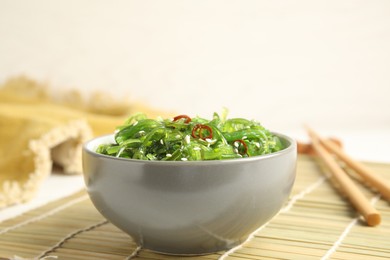 Photo of Japanese seaweed salad served on table, closeup
