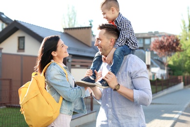 Young woman taking their little child to school