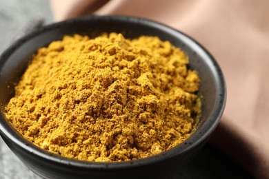 Dry curry powder in bowl on table, closeup