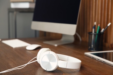 Photo of Stylish headphones on office table. Space for text