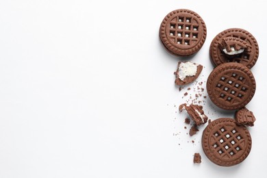 Tasty sandwich cookies with cream on white background, flat lay. Space for text