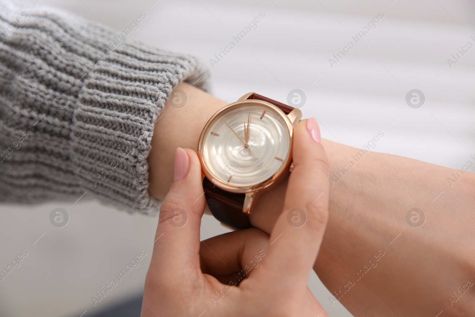 Photo of Woman with luxury wristwatch near window indoors, closeup