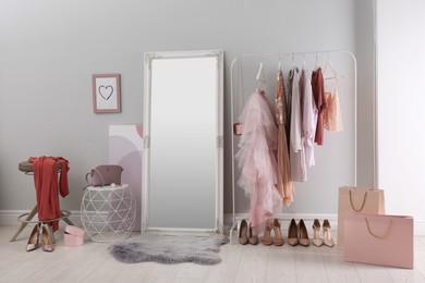 Modern dressing room interior with clothing rack and mirror