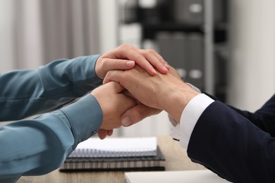 Photo of Trust and deal. Woman with man joining hands in office, closeup