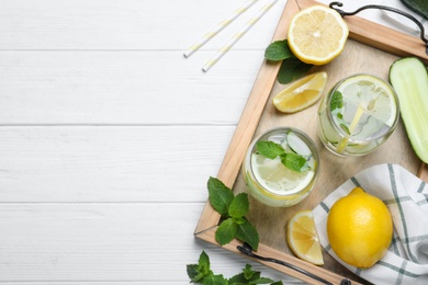 Photo of Refreshing water with cucumber, lemon and mint on white wooden table, top view. Space for text