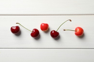 Photo of Sweet red cherries on white wooden table, flat lay